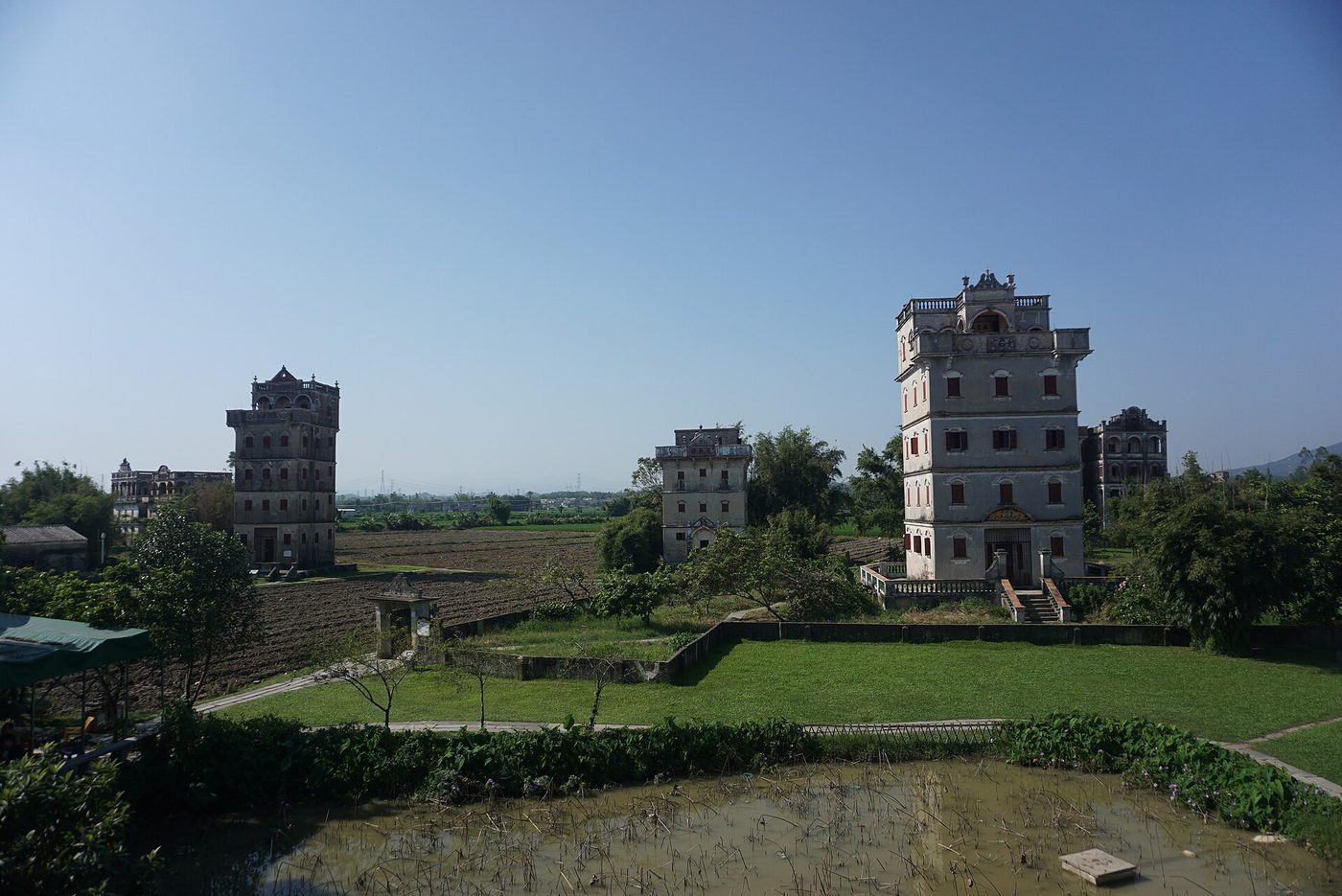 Three diaolou towers standing over farmland in Zili village, Kaiping — Photo: DragonSamYU / CC BY-SA 4.0 via Wikimedia Commons