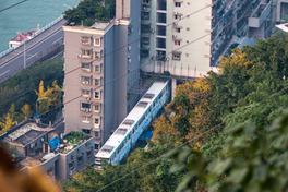 Chongqing Rail Transit Line 2 monorail train passing through a residential building at Liziba station — Photo: Chen Hualin / CC BY-SA 4.0 via Wikimedia Commons
